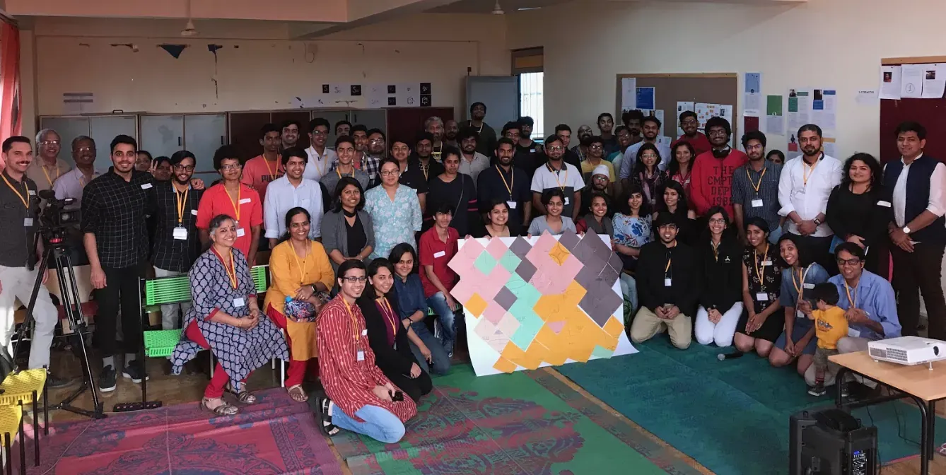 PCD Bangalore participants arranged around a colorful collaborative artwork