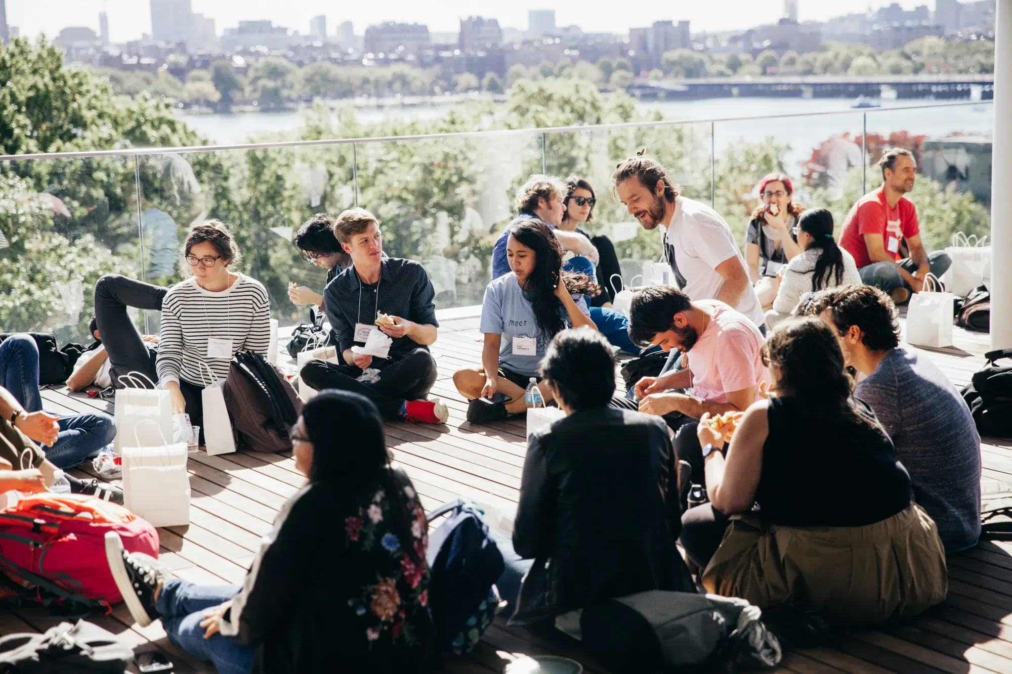 Participants sitting and talking together outdoors during a break at PCD Boston