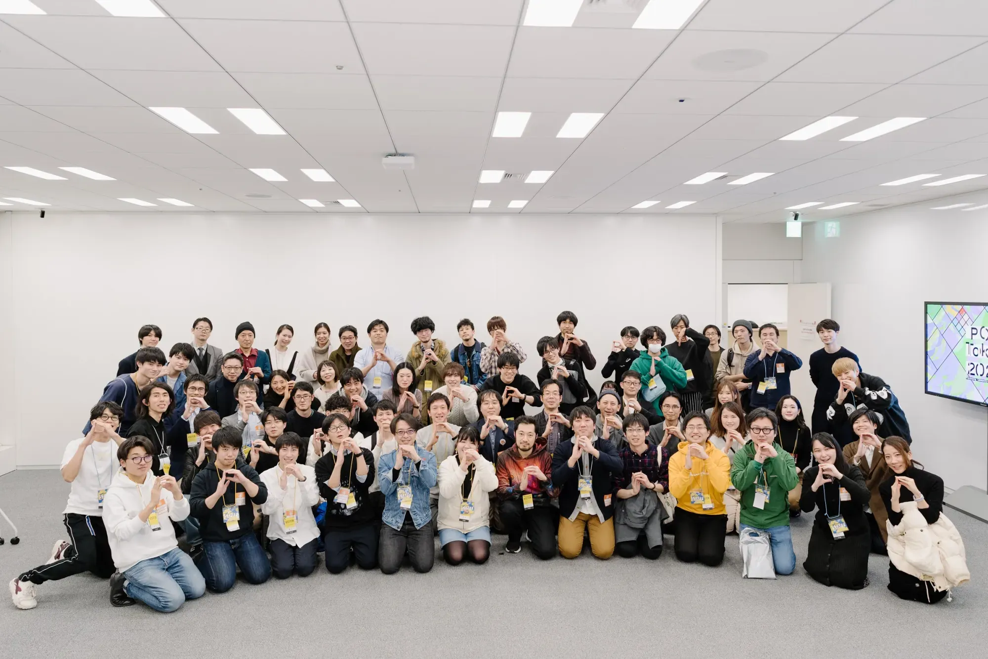A large group of PCD Tokyo participants arranged in rows and looking toward the camera